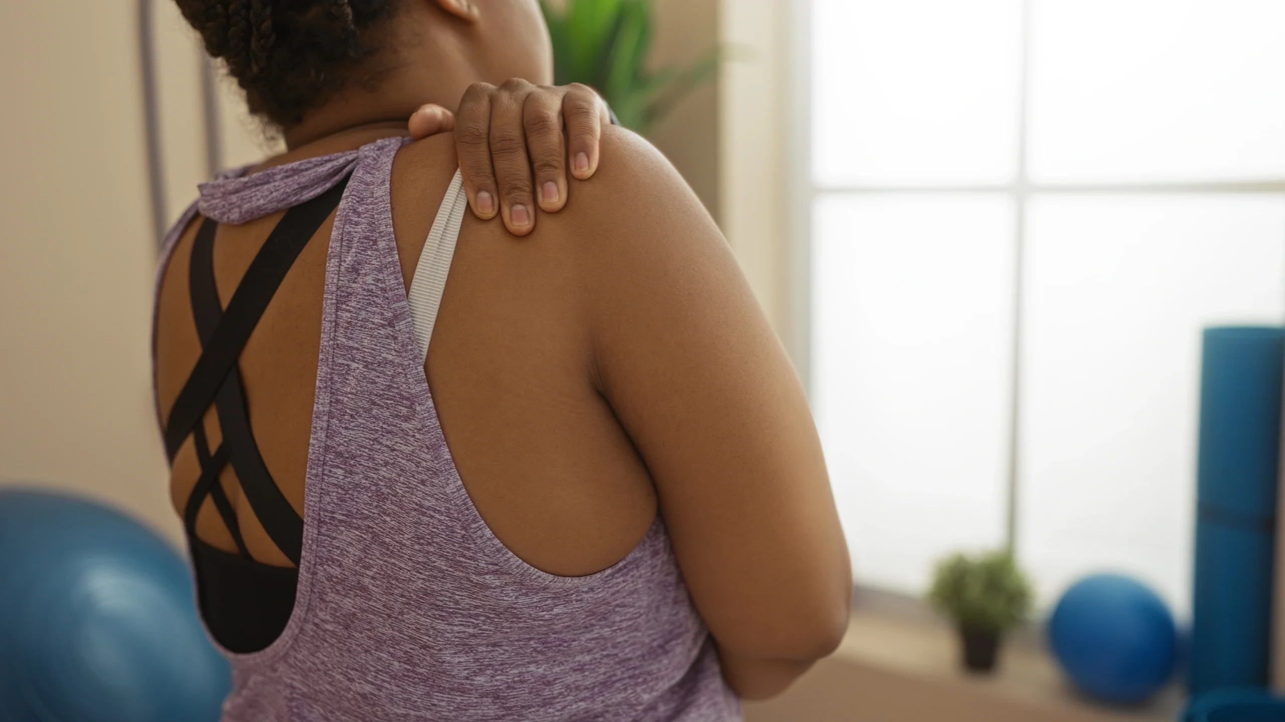 woman experiencing shoulder pain from torn rotator cuff.